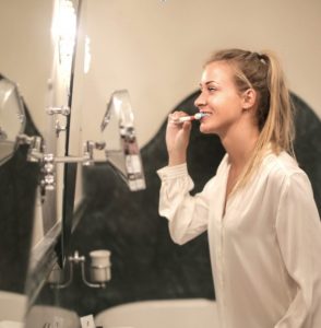 young lady brushing her teeth 