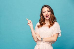 woman smiling and pointing at the top left side