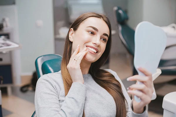 checking her smile after dental treatment
